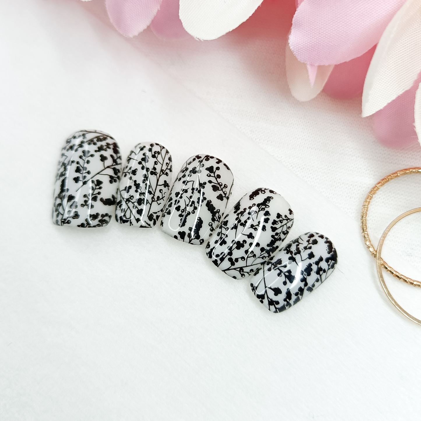 MILKY BLOSSOM – Unghie finte press on bianco lattiginoso con nail art floreale nera