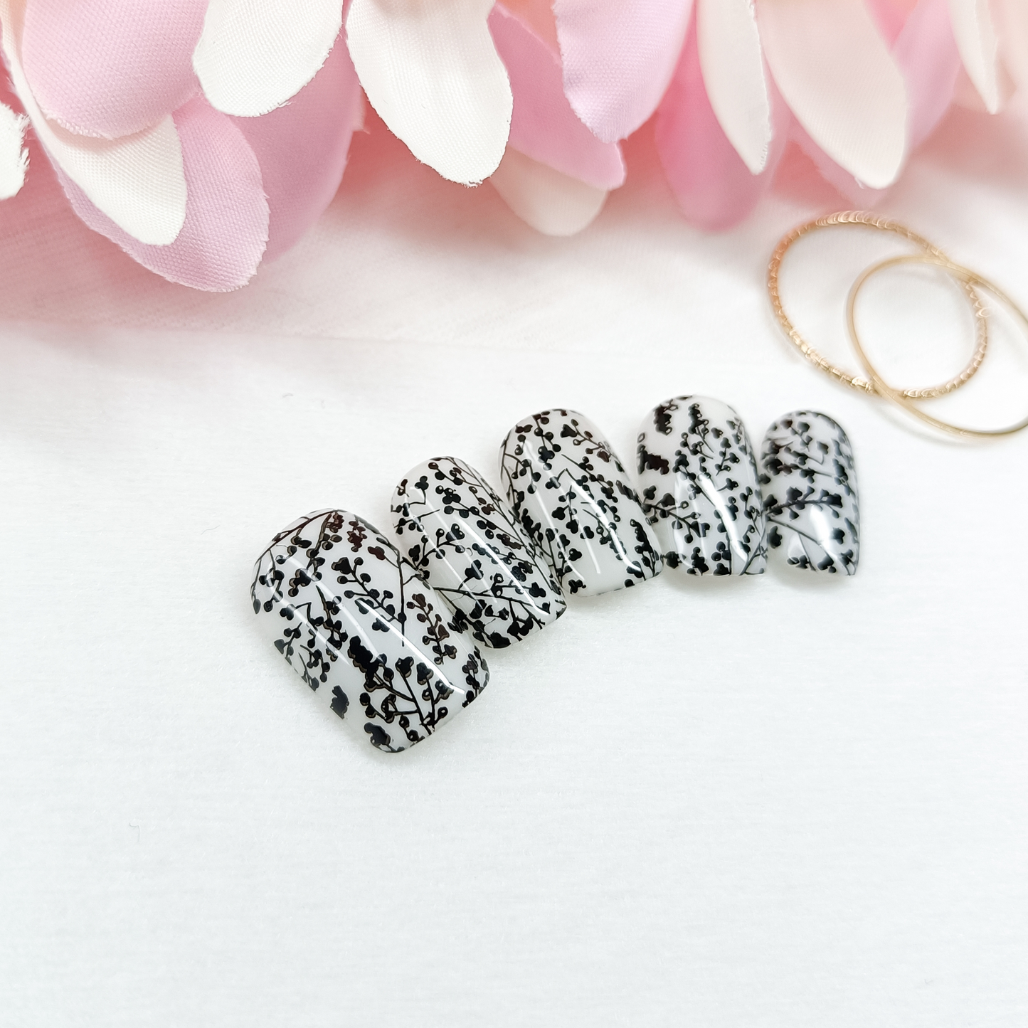 MILKY BLOSSOM – Unghie finte press on bianco lattiginoso con nail art floreale nera