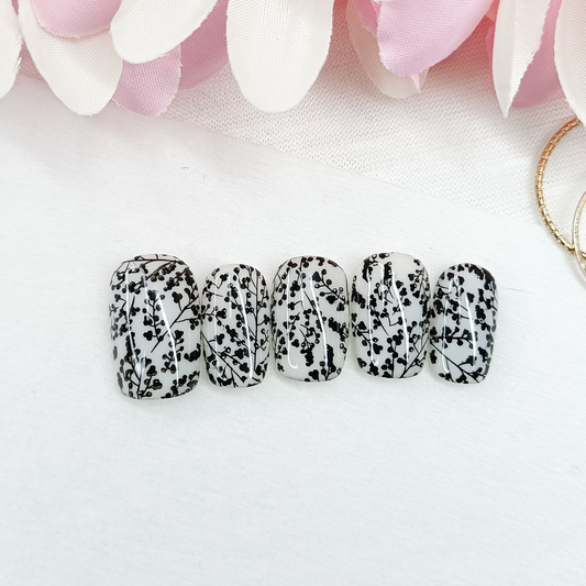 MILKY BLOSSOM – Unghie finte press on bianco lattiginoso con nail art floreale nera